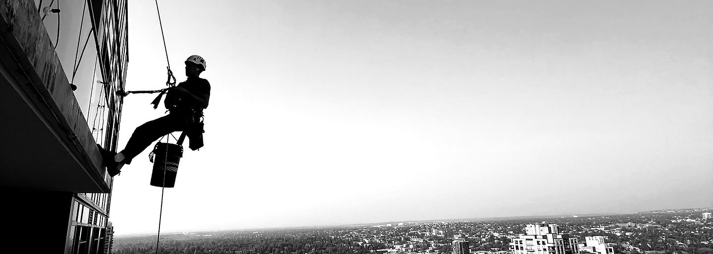 Rope access technician performing high-rise building maintenance in Calgary